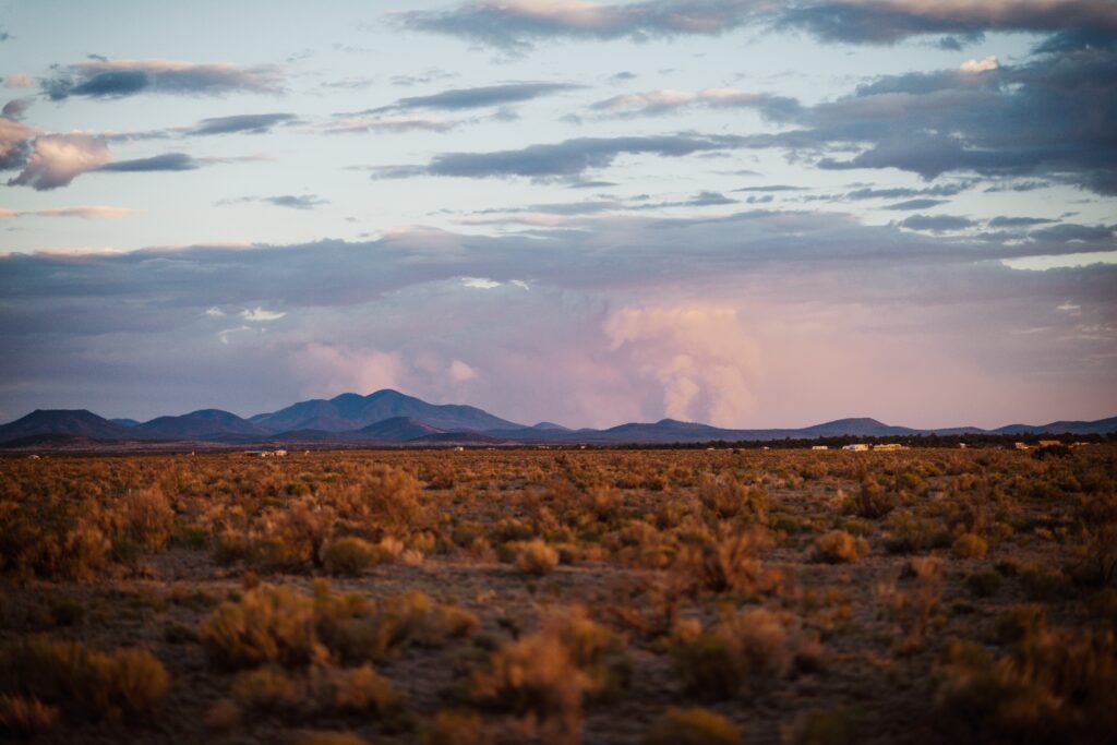 High-desert sagebrush landscape with distant mountains at dusk in northwest New Mexico